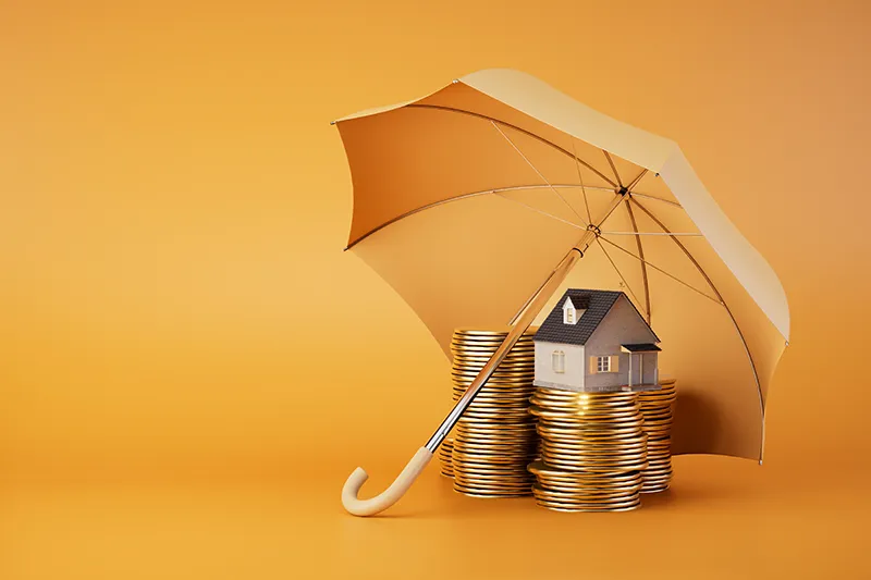 Geld und Haus unter Regenschirm